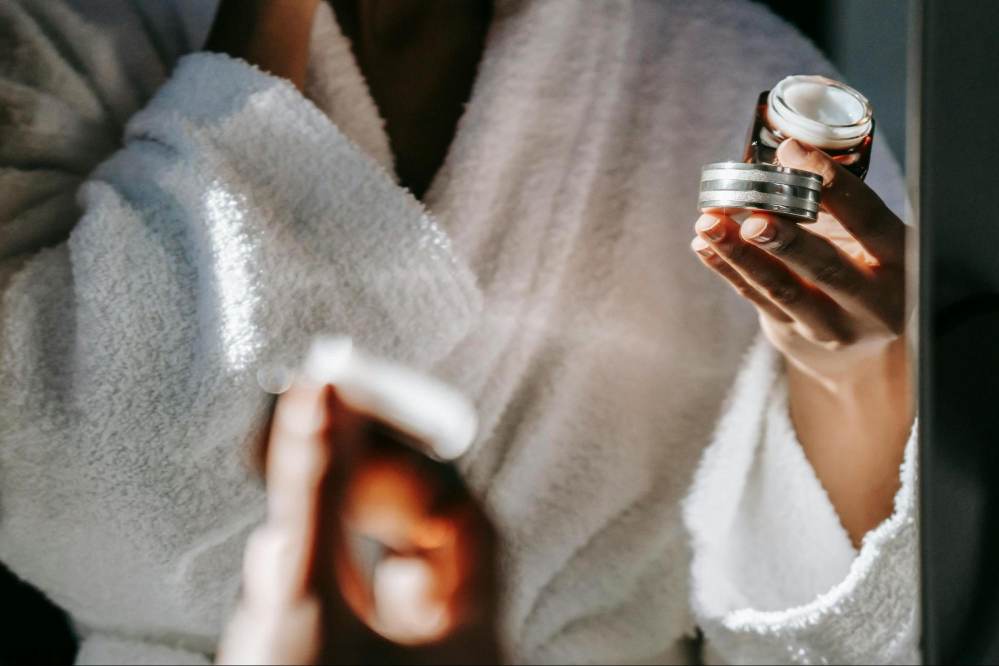 A woman using a niacinamide moisturiser on her damp skin