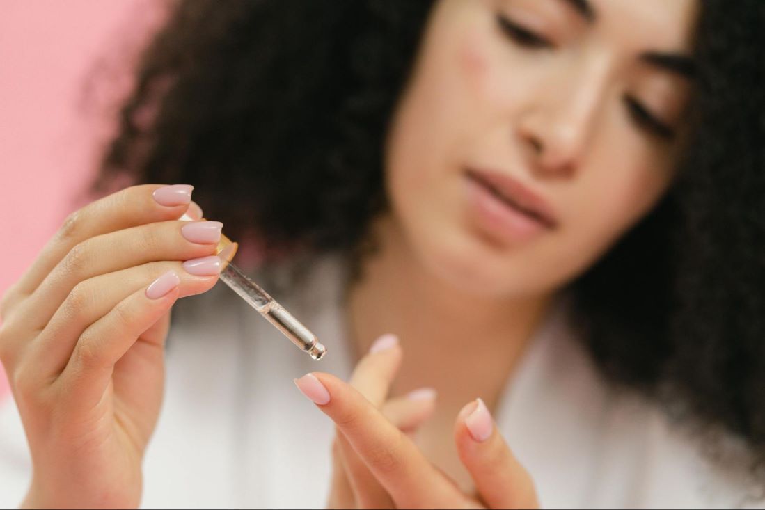 Women Applying niacinamide and glycolic acid serum