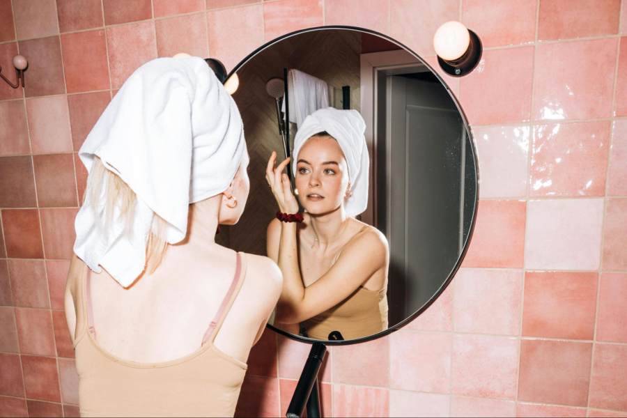 A woman with oily skin looking at herself in the mirror