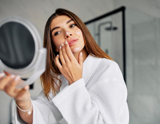 A woman applying lactic acid moisturiser on her face