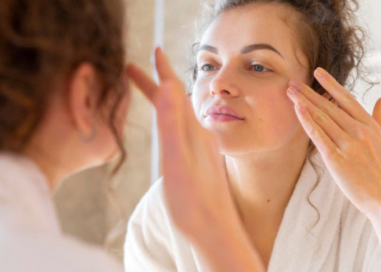 A woman looking at her sensitive facial skin in the mirror