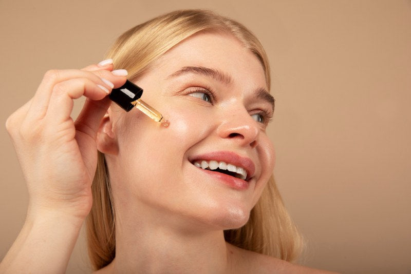 A woman applying an Adapalene (Differin) serum on her face to fight wrinkles
