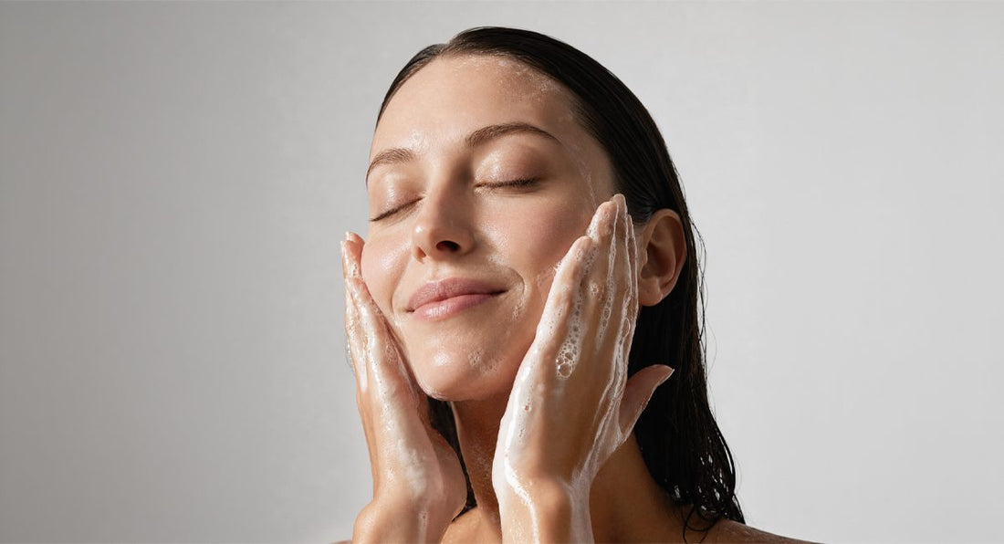 A woman washing her face with a DRSQ hydrating cleanser