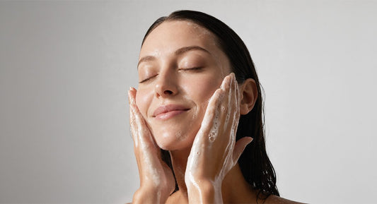 A woman washing her face with a DRSQ hydrating cleanser