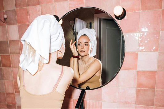 A woman with oily skin looking at herself in the mirror