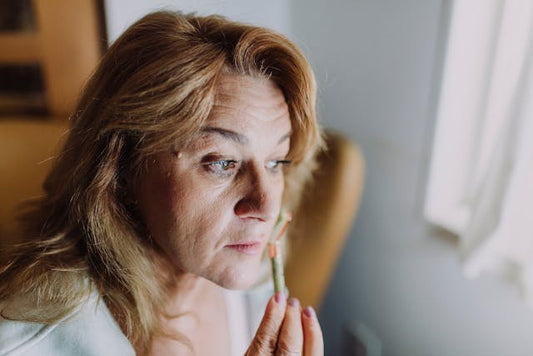 An aged woman massaging her face to reduce wrinkles