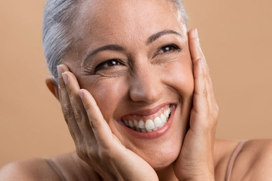 An aged woman admiring her skin after using retinaldehyde serum