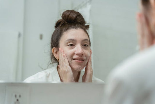 A woman washing her face with a hydrating cleanser