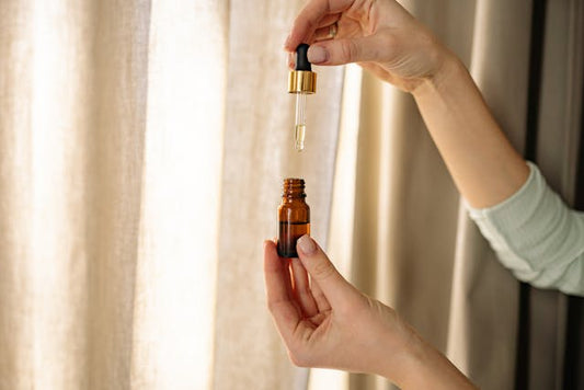 A woman holding a glass bottle containing vitamin C