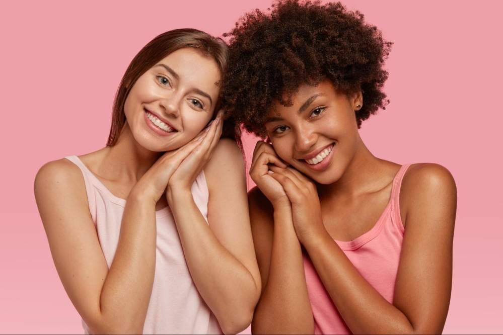 Two women with different skin types admiring their healthy skin
