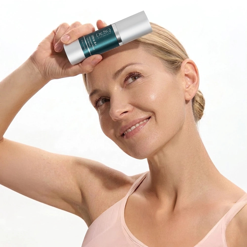 A middle-aged woman is posing with a bottle of Ultra A+ serum