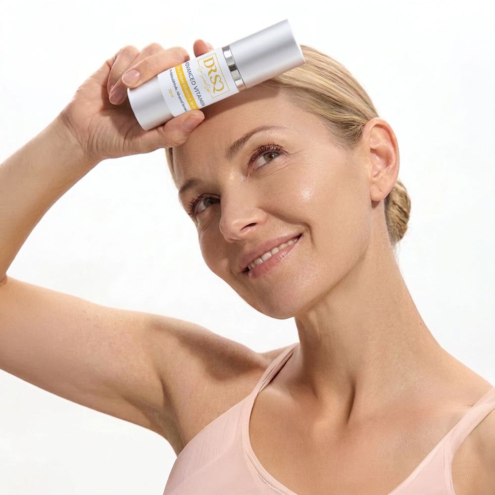 A middle-aged woman is posing with a bottle of Advanced Vitamin A serum