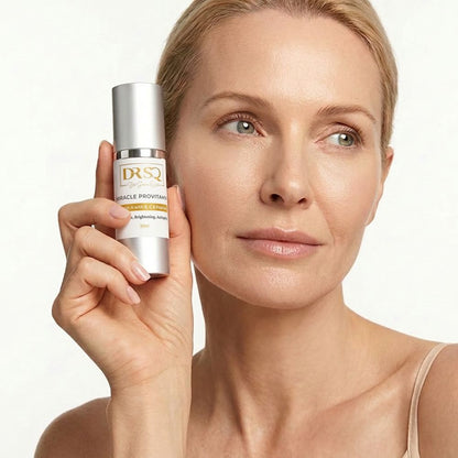 A middle-aged woman with fine lines is posing with DRSQ Miracle Pro Vitamin serum